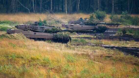 Kampfpanzer vom Typ Leopard fahren nahe Bergen über einen Übungsplatz. © dpa Foto: Philipp Schulze