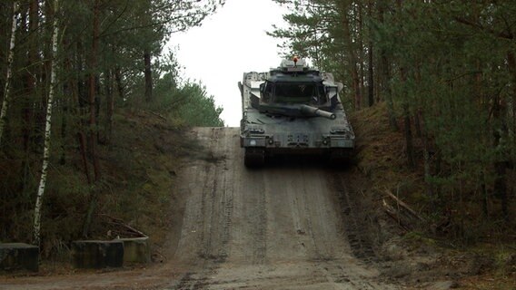 Ein Panzer fährt einen Hügel runter. © NDR 