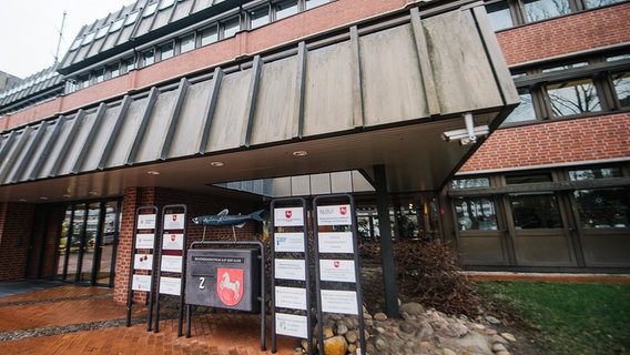 Vor dem Eingang des Behördenzentrums in Lüneburg stehen Hinweistafeln für verschiedene Ämter und Behörden. © NDR Foto: Julius Matuschik