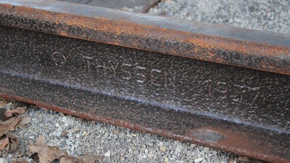 Das Bild zeigt Bahnschienen mit der Inschrift "Thyssen 1937". © NDR Foto: Lars Gröning