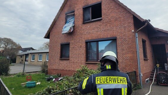 Einsatzkräfte der Feuerwehr stehen vor einem beschädigten Wohnhaus. © Kreisfeuerwehr Rotenburg (Wümme) 
