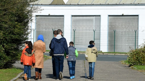 Flüchtlinge gehen am 26.10.2015 in Bad Fallingbostel (Niedersachsen) im neuen Camp Ost. © Holger Hollemann Foto: picture alliance / dpa