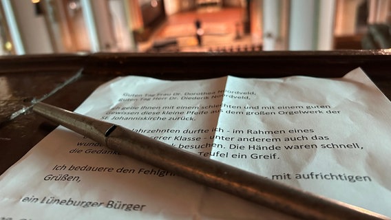 Eine Orgelpfeife und der Brief eines reuigen Diebs liegen in einer Kirche. © NDR Foto: Marie Schiller