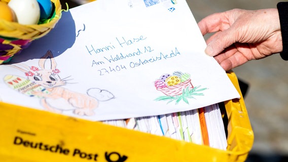 Eine Mitarbeiterin im Osterpostamt hält einen Brief, den ein Kind an den Osterhasen Hanni Hase geschrieben hat, in den Händen. © picture alliance Foto: Hauke-Christian Dittrich