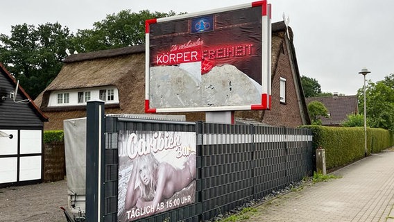 Ein beschädigtes Plakat mit dem Text "Zu verkaufen Körper Freiheit Würde" vor einem Bordell in Buxtehude © Hansestadt Buxtehude 