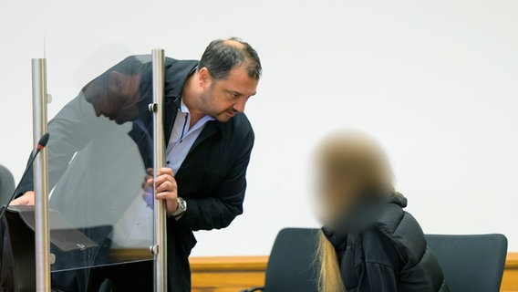Die Angeklakte (r) spricht im Saal des Landgerichtes mit ihrem Anwalt Oguz Bozkurt Ögüt. Ein junges Paar muss sich vor dem Landgericht in Lüneburg verantworten, weil es im Juli 2021 in Lüder im Landkreis Uelzen die hinteren Bremsschläuche eines Autos durchgeschnitten haben soll. © picture alliance/dpa | Philipp Schulze Foto: Philipp Schulze