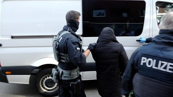 Ein Mann wird von maskierten Polizisten abgeführt © NEWS5 