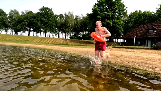 Klaus Kläre springt als Rettungsschwimmer in einen See in Fredenbeck. © NDR 
