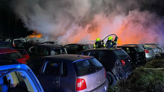 Feuerwehrleute löschen auf dem Gelände eines Autoverwerters einen Brand. © Kreisfeuerwehr Rotenburg (Wümme) 