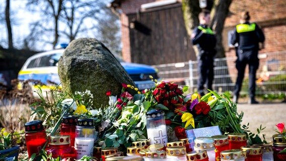 Blumen und Kerzen liegen vor einem Einfamilienhaus. Blumen und Kerzen liegen vor einem Einfamilienhaus. © dpa-Bildfunk Foto: Sina Schuldt