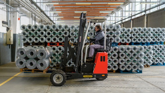 The fence against the spread of African Swine Fever (ASF) is driven into a hall with a forklift.  © dpa Photo: Philipp Schulze