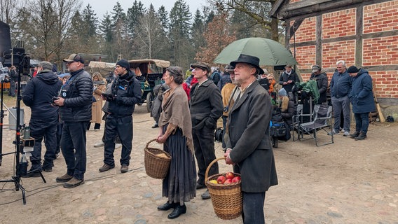 Komparsen warten auf ihren Einsatz bei den Dreharbeiten für Schwarzes Gold. © NDR Foto: Tabea Pander