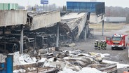 Ausgebrannte Busse stehen nach einem Brand in Sittensen im Landkreis Rotenburg auf einem Firmengelände. © dpa Foto: Georg Wendt