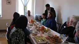 Ein Flüchtlingsfamilie aus Syrien sitzt in ihrem Wohnzimmer und trinkt Kaffee. © NDR Foto: Marie Elane Schulz