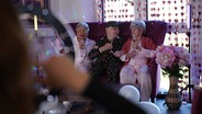 Drei Bewohner einer Seniorenresidenz in Schneverdingen sitzen auf einem Sofa und drehen ein TikTok-Video © NDR Foto: Carsten Busch