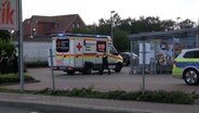 Ein Krankenwagen steht nach einer Messerattacke auf einem Supermarktparkplatz. © TV-Elbnews 