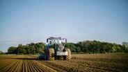 A tractor in a farm field goes through a field.  © NDR Photo: Julius Matuschik