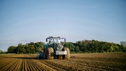 Ein Trecker auf einem Landwirtschaftlich genutzten Feld durchpflügt einen Acker. © NDR Foto: Julius Matuschik