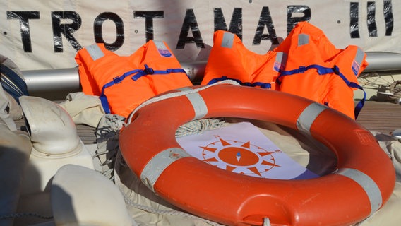 Auf dem Segelschiff "Trotamar III" liegen Schwimmwesten und ein Rettungsring. © CompassCollective 