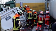 Einsatzkräfte der Feuerwehr befreien einen Fahrer eines Wohnmobils nach einem Unfall auf der Autobahn 1. © TV7News 
