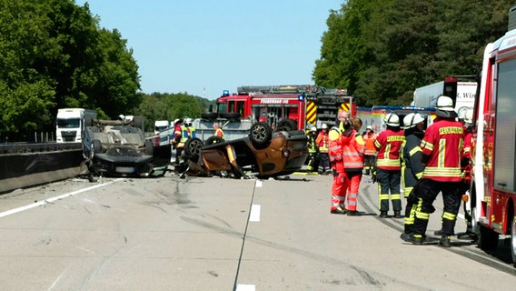 Einsatzkräfte der Feuerwehr stehen nach einem Unfall auf der A7 bei Toppenstedt. © NEWS5 