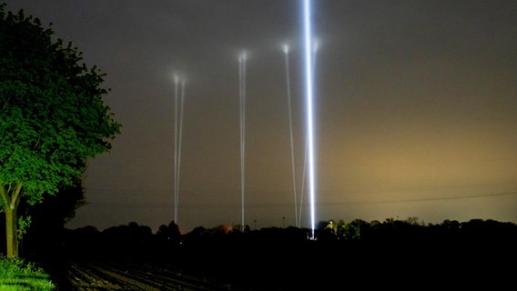 Mehrere Skybeamer leuchten in den Nachthimmel von Bremervörde. Hier wird nach dem vermissten Arian gesucht. © dpa-Bildfunk/ Jonas Walzberg Foto: Jonas Walzberg