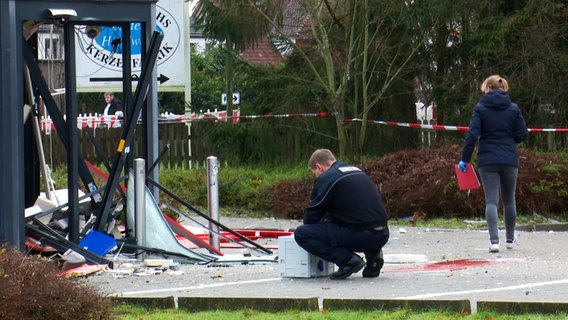 Zwei Polizisten untersuchen einen gesprengten Geldautomaten in Walsrode auf dem Parkplatz eines Supermarktes © Hannover Reporter 