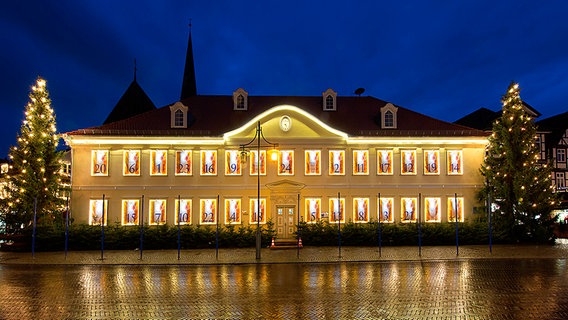 Das in einen Adventskalender umgewandelte Rathaus der Stadt Uelzen vor dunkelblauem Himmel. © Stadt Uelzen Foto: O. Huchthausen