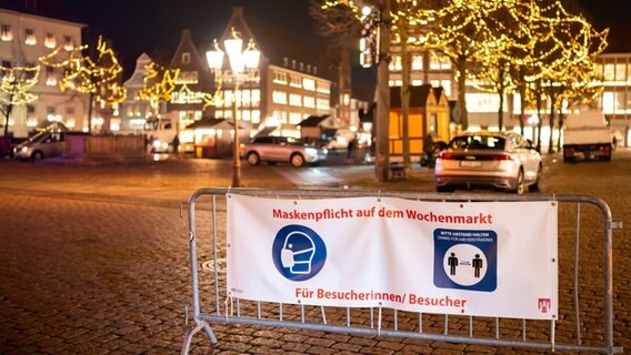 in Lüneburg wird der Weihnachtsmarkt aufbegaut, ein Schild weist auf Masken- und Abstandpflicht hin. © dpa-Bildfunk Foto: Philipp Schulze