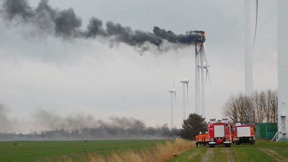 Einsatzwagen der Feuerwehr stehen vor einer brennenden Windkraftanlage. © Polizeiinspektion Stade 