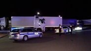 Polizeibeamte stehen auf einem Parkplatz in Winsen vor mehreren Lkws. © Hellwig TV Elbnews Produktion 