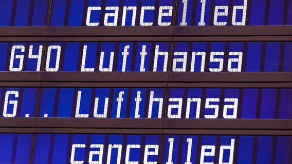 Die Worte "cancelled" und "Lufthansa" werden an einer Anzeigentafel an einem Flughafen angezeigt. © dpa-Bildfunk Foto: Peter Kneffel