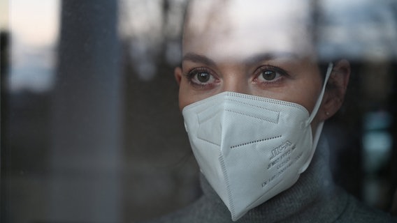 Eine Frau mit Mund Nasenschutz Maske vom Typ FFP2. © picture alliance Foto: Frank May