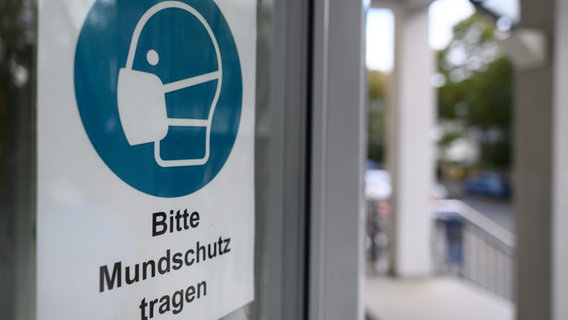 Ein Schild "Bitte Mundschutz tragen" ist am Eingang eines Krankenhauses angebracht. © picture alliance/dpa/dpa-Zentralbild | Robert Michael Foto: Robert Michael