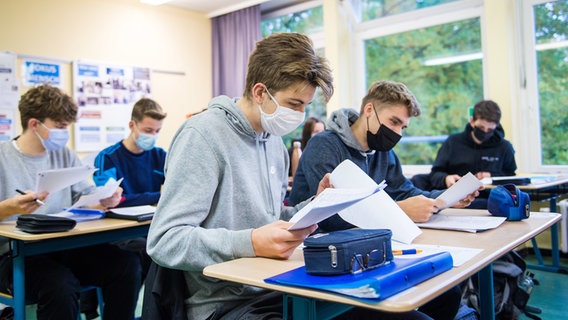 Schüler sitzen mit Mund-Nasen-Bedeckungen im Unterricht. © picture alliance Foto: Daniel Bockwoldt