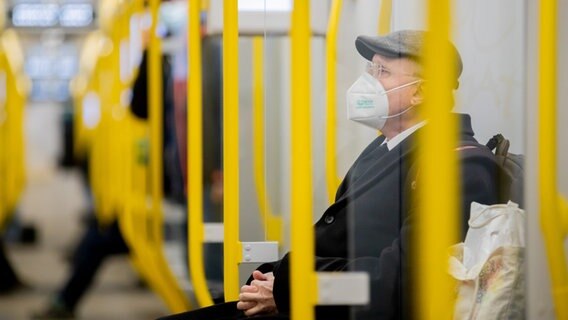 Ein Mann sitzt mit einer FFP2-Maske in einer U-Bahn. © picture alliance/dpa | Christoph Soeder Foto: Christoph Soeder