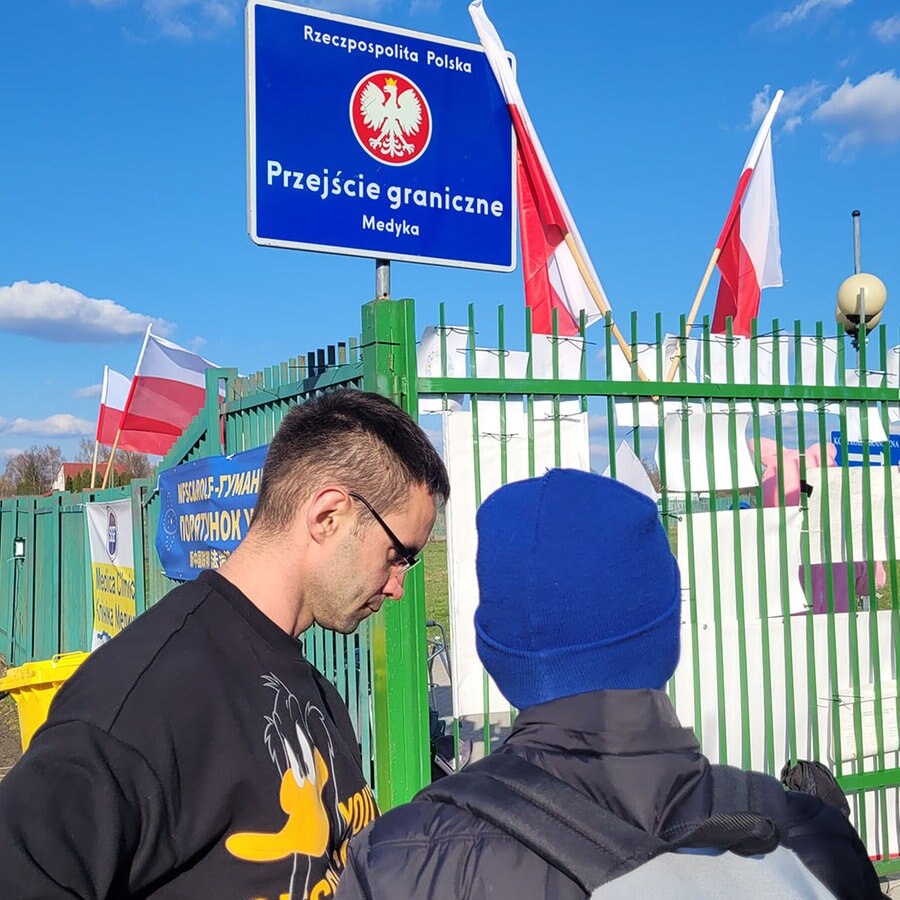 Personen stehen vor einem Schild mit der Aufschrift "Rzeczpospolita Polska - Przejście graniczne - Medyka". © NDR Foto: Jan Bockemüller