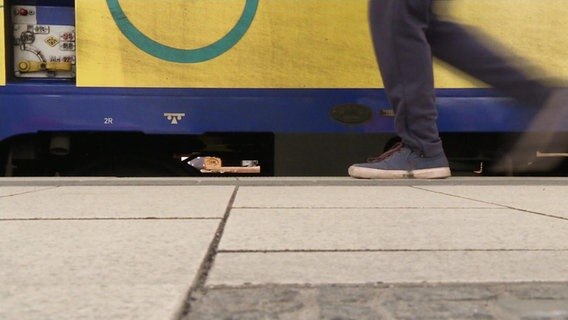 Schuhe eines Reisenden vor einem Metronom (Froschperspektive). © NDR 