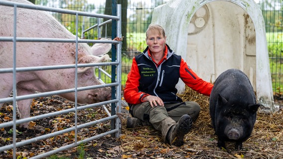 Ebstorf: Sabine Bracker, Vorsitzende vom Verein für misshandelte Tiere e.V., kniet neben einem circa 5 Jahre alten Minischwein (r) und einem Masthybridschwein (l). © dpa-Bildfunk Foto: Philipp Schulze