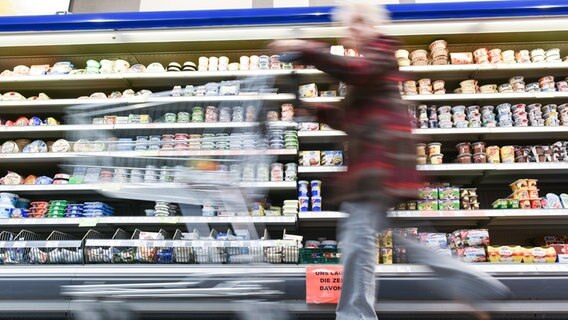 Eine Kundin geht in einem Supermarkt mit ihrem Einkaufswagen an einem Kühlregal vorbei. © picture alliance/dpa | Uwe Anspach Foto: Uwe Anspach