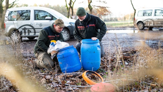 Die beiden Förster Stefan Heidecke (l) und Knut Sierk inspizieren illegal entsorgten Müll auf einem Waldparkplatz. © picture alliance/dpa Foto: Philipp Schulze