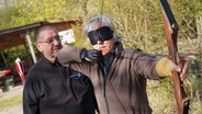Kursteilnehmerin schießt mit verbundenen Augen in der Bowhunter World Hannover. © NDR Foto: Marcel Seemann
