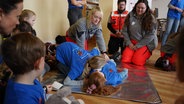 Kinder und Ehrenamtliche der Johanniter Salzgitter üben Erste-Hilfe-Maßnahmen. © NDR Foto: Theresa Möckel