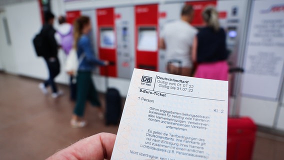 Ein 9-Euro-Ticket für den Monat Juli ist vor einer Reihe Kartenautomaten © picture alliance/dpa Foto: Christian Charisius