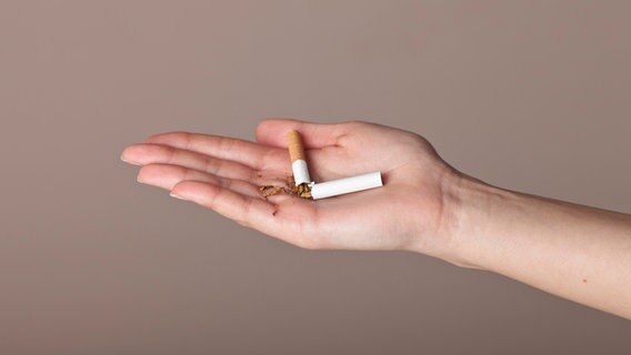 Eine zerbrochene Zigarette liegt in einer Hand. © picture alliance / imageBROKER | zeitgeist images 