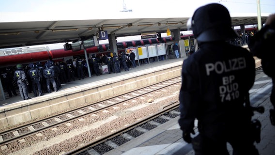 Bundespolizisten stehen auf einem Bahnsteig im Braunschweiger Hauptbahnhof und beobachten Fußballfans von Hannover 96. © picture alliance / dpa | Alexander Körner Foto: Alexander Körner