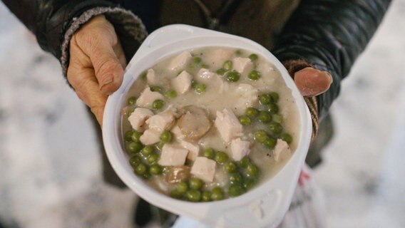Eine Person hält eine Schale mit Suppe in den Händen. © picture alliance/dpa Foto: Ole Spata