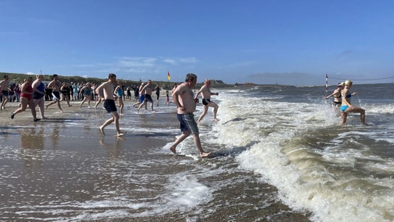 Menschen springen in die Nordsee auf Baltrum. © Gemeinde- u. Kurverwaltung Baltrum 