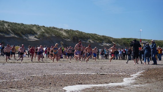 Menschen springen in die Nordsee auf Baltrum. © Gemeinde- u. Kurverwaltung Baltrum 