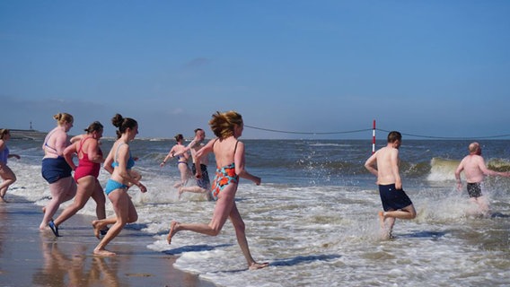 Menschen springen in die Nordsee auf Baltrum. © Gemeinde- u. Kurverwaltung Baltrum 